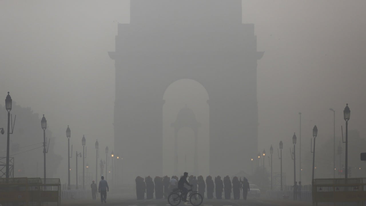 A man rides his bicycle next to Indian soldiers marching in front of India's door on a foggy morning in New Delhi. Reuters