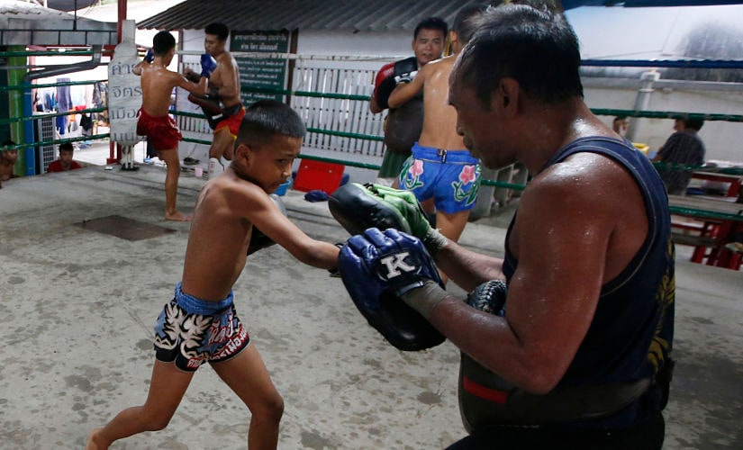 In this Wednesday, Nov. 14, 2018, photo, Thai kickboxer Chaichana Saengngern, 10-years old, spars at a training camp in Bangkok, Thailand. Thai lawmakers recently suggested barring children younger than 12 from competitive boxing, but boxing enthusiasts strongly oppose the change. They say the sport is part of Thai culture and gives poor families the opportunity to raise a champion that will lift their economic circumstances. (AP Photo/Sakchai Lalit)