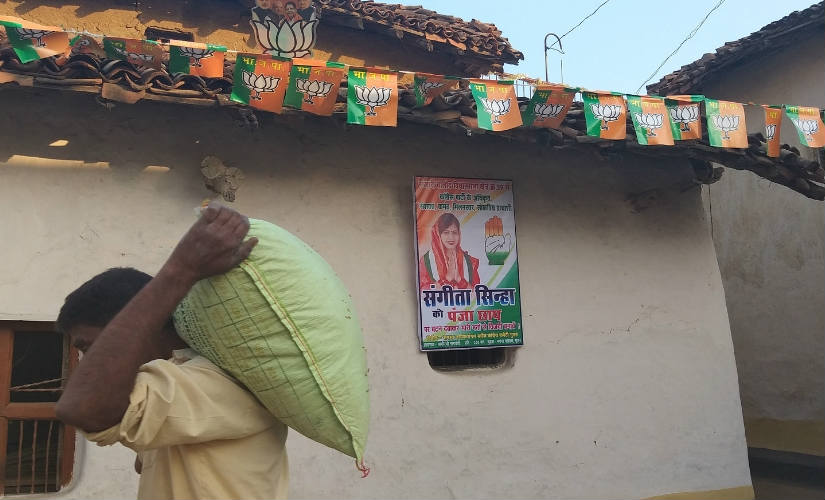 A man walking past a poster of Congress candidate Sangeeta Sinha. Natasha Trivedi