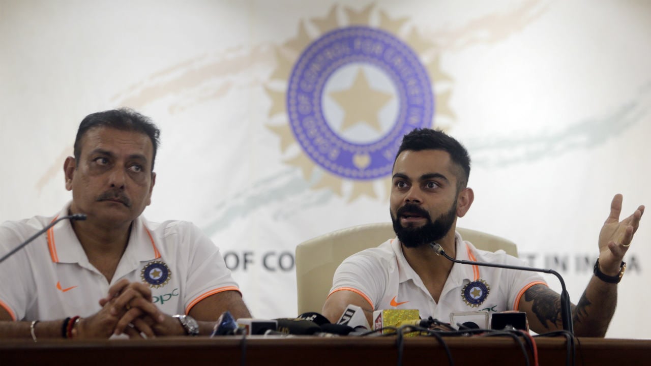 Indian cricket captain Virat Kohli speaks with head coach Ravi Shastri by his side before the team's departure for their Australia tour, in Mumbai, India, Thursday, Nov. 15, 2018. (AP Photo/Rajanish Kakade)