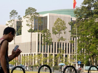 Tourists walk past Vietnam's National Assembly (Parliament) building in Hanoi. Reuters