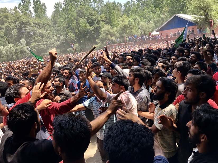Volunteers in Kulgam try to keep people at bay from a podium where militants are addressing a funeral prayer for a slain comrade. Image Courtesy: Sameer Yasir