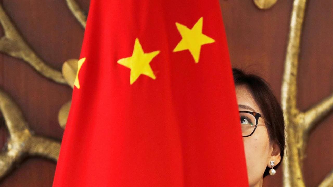 FILE PHOTO: A Chinese official adjusts a Chinese flag before the start of a meeting between Foreign Minister Wang Yi and Indian Foreign Minister Sushma Swaraj in New Delhi, India, December 21, 2018. REUTERS/Adnan Abidi