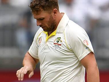 Australia’s batsman Aaron Finch has his injured finger inspected after being struck by an Indian delivery on the third day of the second cricket Test match in Perth on December 16, 2018. (Photo by WILLIAM WEST / AFP) / –IMAGE RESTRICTED TO EDITORIAL USE - STRICTLY NO COMMERCIAL USE–