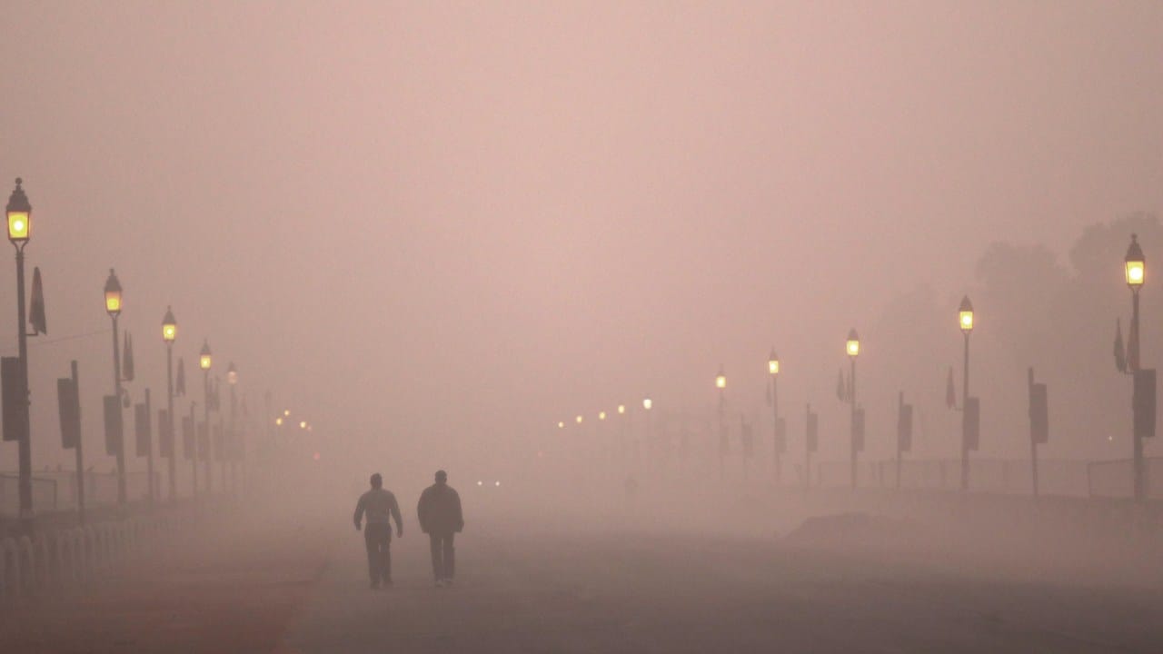Residents take an early morning walk in smog in Delhi. AP