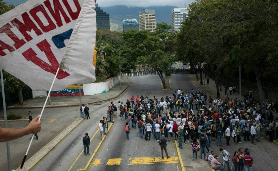 Students from the Central University of Venezuela gathered as riot police formed a cordon in the rear, during the walk out against Maduro. Guaido told the University students at a surprise appearance: Students from the Central University of Venezuela gathered as riot police formed a cordon in the rear, during the walk out against Maduro. Guaido told the University students at a surprise appearance: