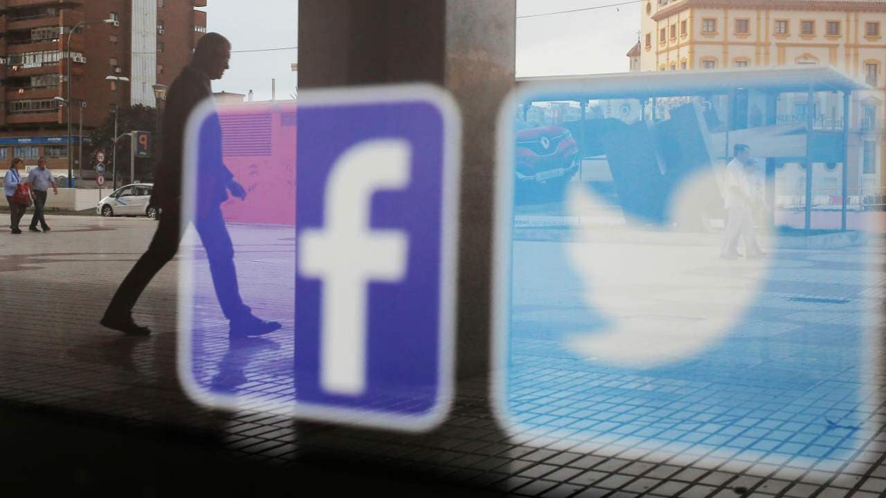 Facebook and Twitter logos are seen on a shop window. Image: Reuters