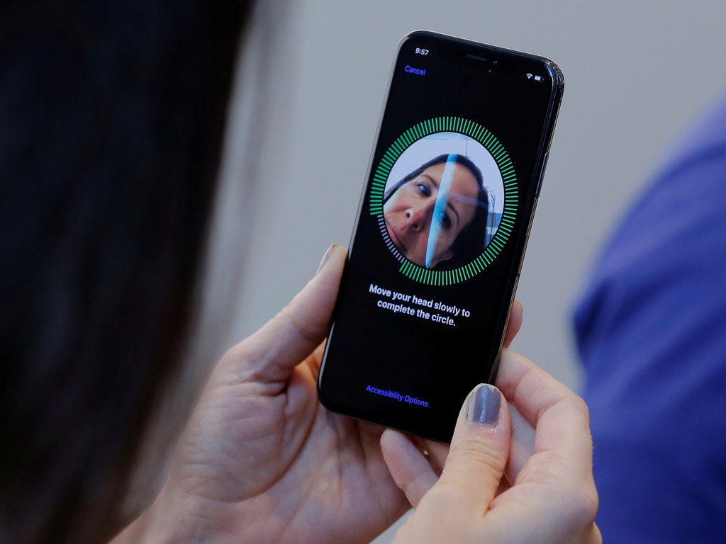A woman sets up her facial recognition on her iPhone X. Image: Reuters