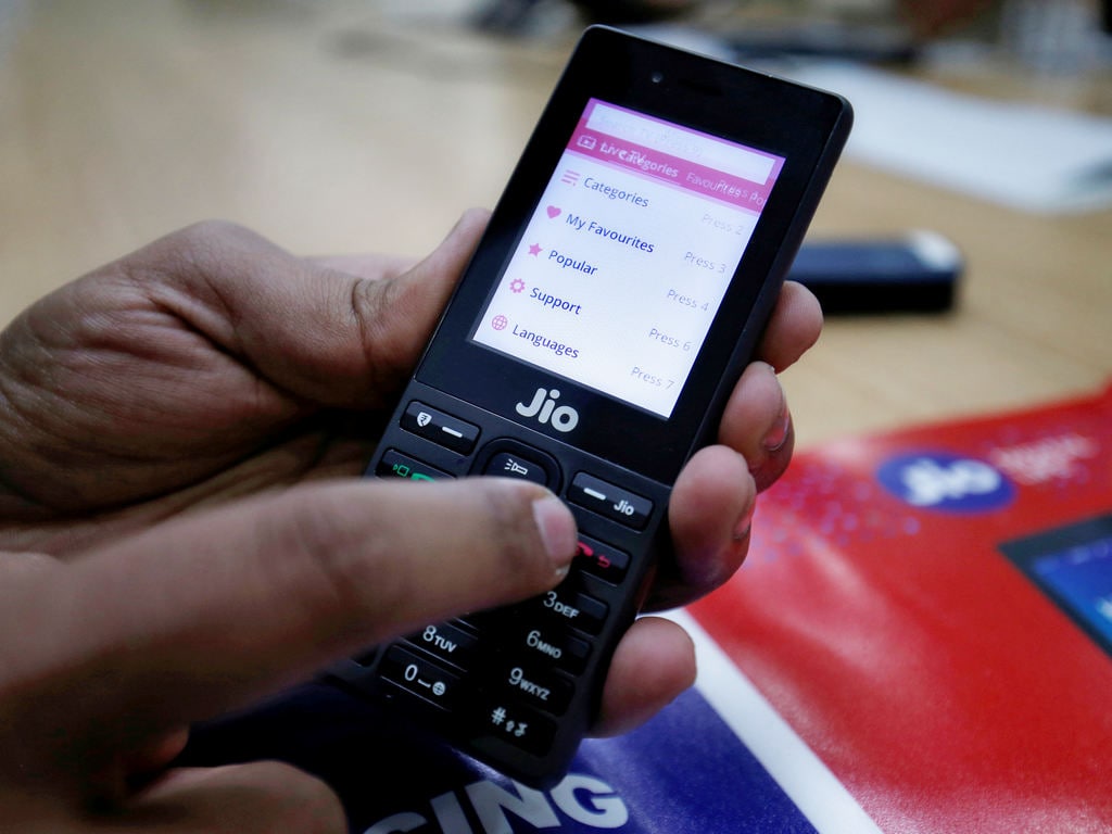 A sales person displays features of JioPhone. Reuters
