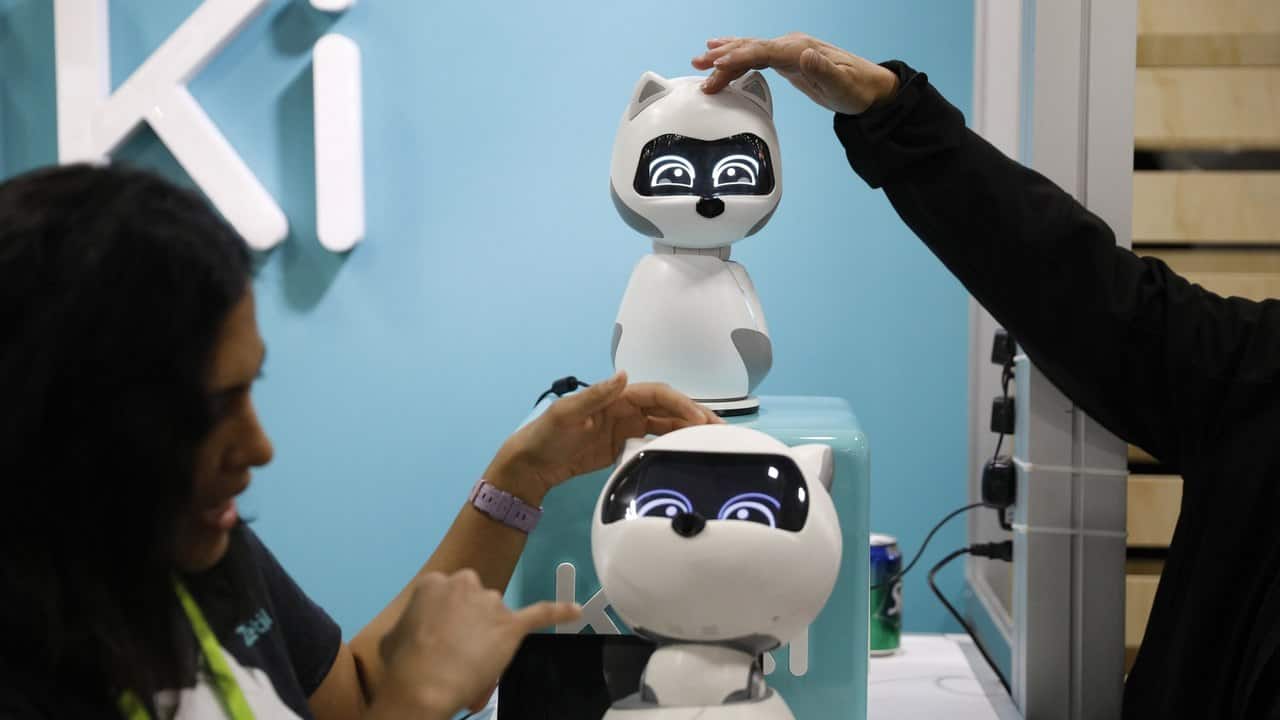 People touch Kiki robots at the Zoetic AI booth at CES. Image: AP