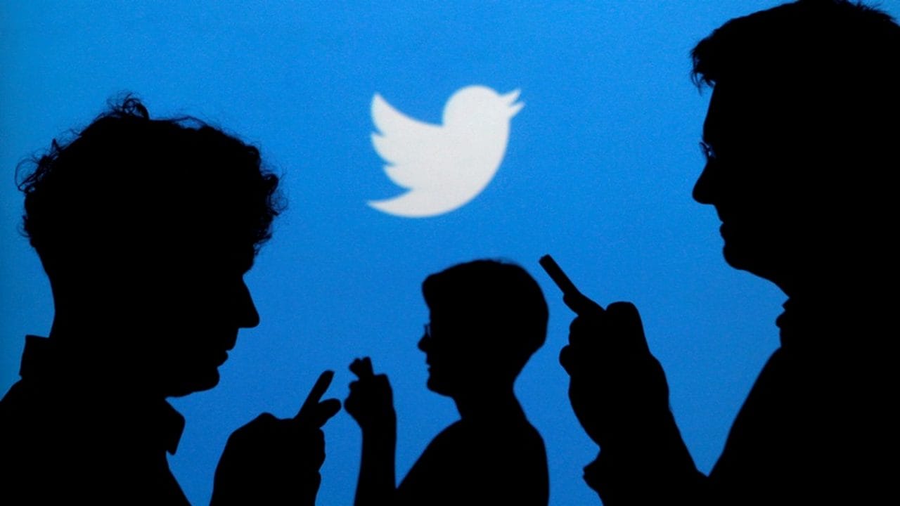 FILE PHOTO: People holding mobile phones are silhouetted against a backdrop projected with the Twitter logo in this illustration picture. Image: Reuters.