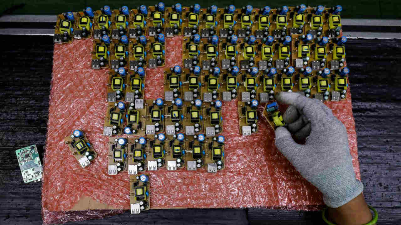 A worker arranges battery charger circuit boards at a mobile phone battery manufacturing plant in Noida, India, October 12, 2018. Picture taken October 12, 2018. REUTERS/Anushree Fadnavis/File Photo