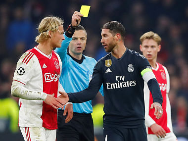 Soccer Football - Champions League Round of 16 First Leg - Ajax Amsterdam v Real Madrid - Johan Cruijff Arena, Amsterdam, Netherlands - February 13, 2019 Real Madrid's Sergio Ramos is shown a yellow card by referee Damir Skomina as Ajax's Kasper Dolberg looks on REUTERS/Wolfgang Rattay - RC1569EE6500
