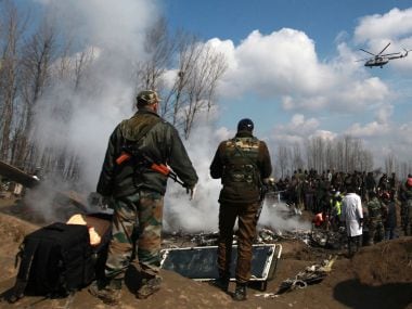 stand next to the wreckage of Indian Air Force's helicopter after it crashed in Budgam district in Kashmir. Reuters