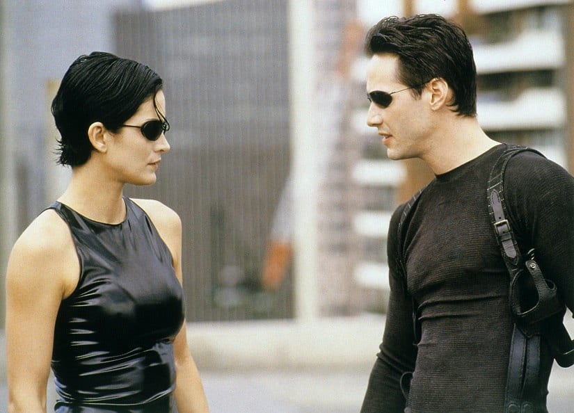 Reeves (R) with Carrie-Anne Moss in another still from the film. Image via Twitter