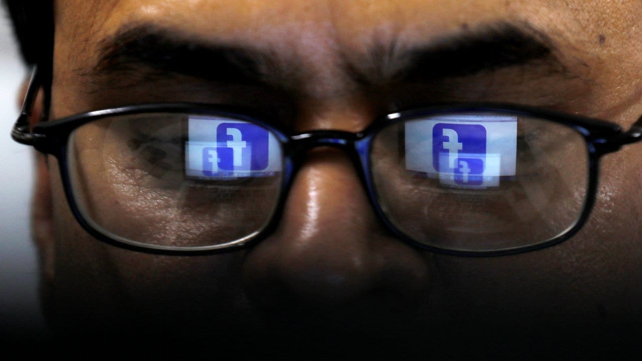 Facebook logo is reflected in glasses. Reuters