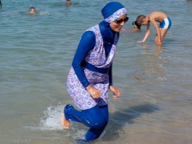 A woman wearing a burkini walks in the water in 2016 on a beach in Marseille, France, the day after the country’s highest administrative court suspended a ban on full-body burkini swimsuits. Reuters