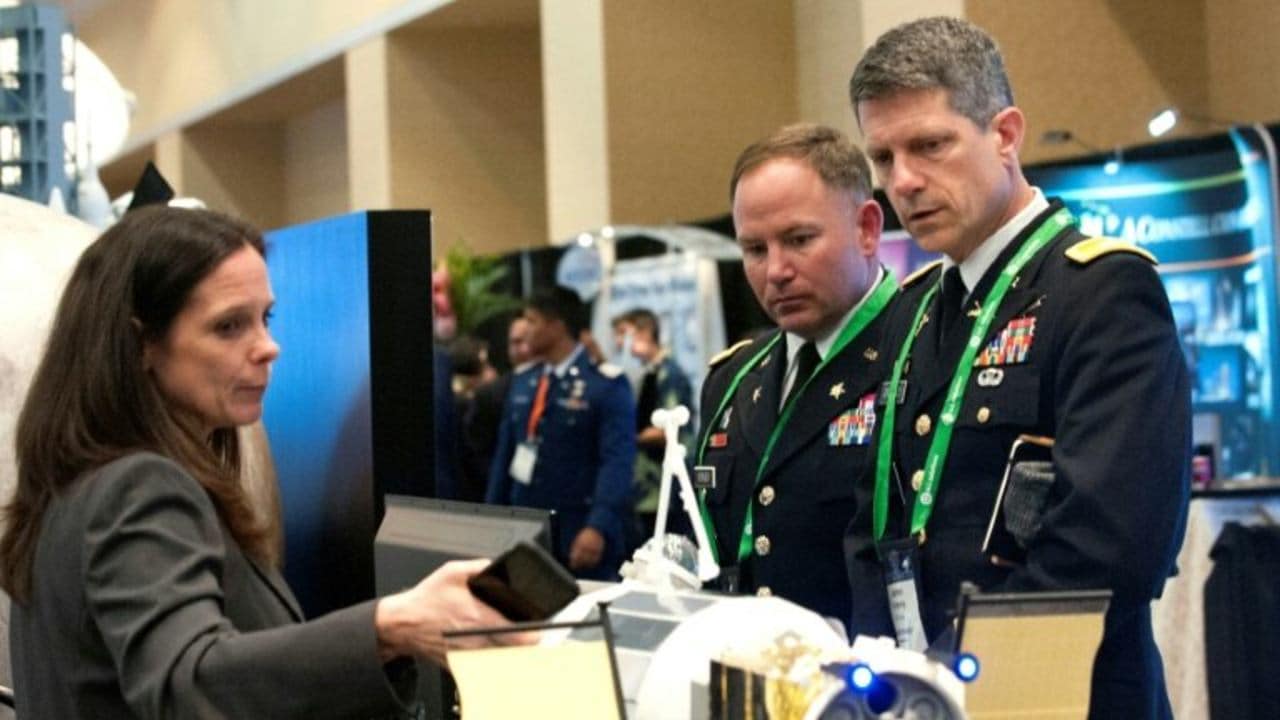 A NASA exhibitor discusses the features of a rocket with members of the US military during the 35th Space Symposium in Colorado, the largest space trade show in the world. Image: AFP.