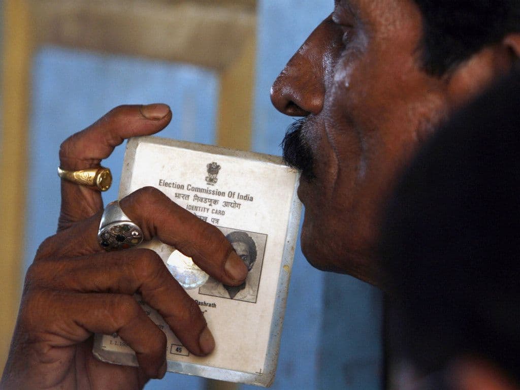 File photo of a man holding his voter identity card. Image: Reuters