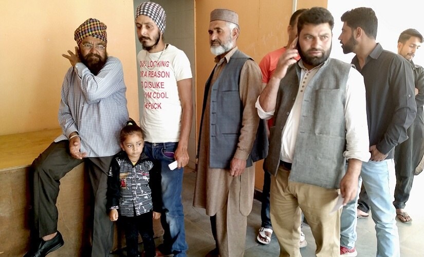 Jitender Singh (in white T-shirt) waits for his turn at a polling station in Uri. Firstpost/Sameer Yasir