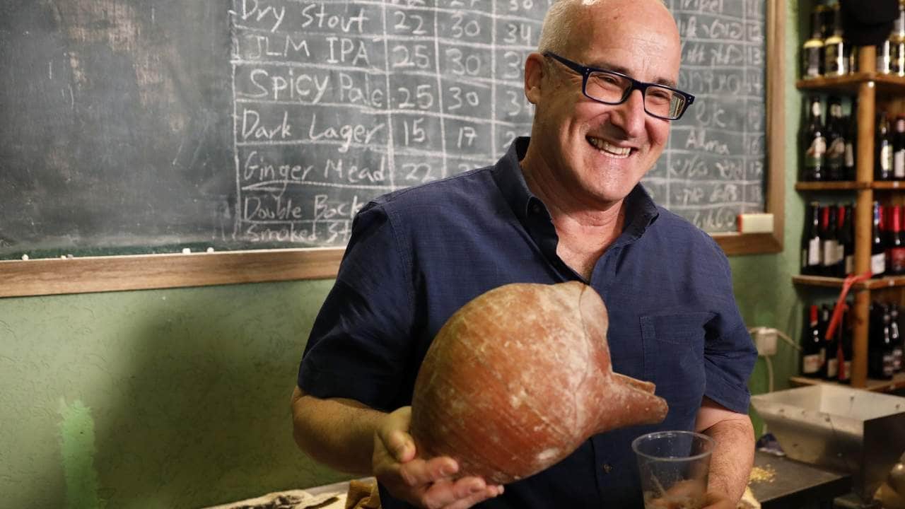 Prof. Aren Maeir, from Bar Ilan University, holds an ancient jar and a glass of beer during a press conference in Jerusalem, Wednesday, May 22, 2019. Israeli researchers celebrated Wednesday a long-brewing project of making beer and mead using yeasts extracted from ancient clay vessels -- some over 5,000 years old. Archaeologists and microbiologists teamed up to study yeast colonies found in microscopic pores in ancient pottery fragments. (AP Photo/Sebastian Scheiner)
