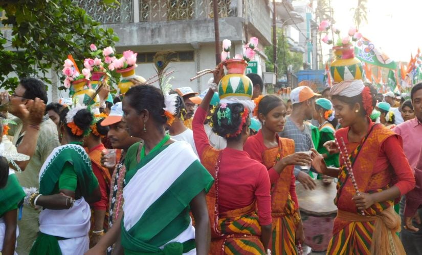 Nusrat's roadshow moves through the shop-lined main road of Basirhat like a royal wedding procession, complete with tribal dancers in green-and-white saris and sneakers, balancing pots of fake flowers on their heads. Image by Sandip Roy