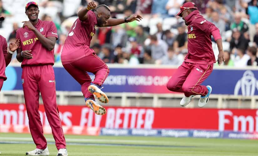 West Indies' bowler Andre Russell celebrates taking the wicket of Pakistan's Haris Sohail with Darren Bravo. AP