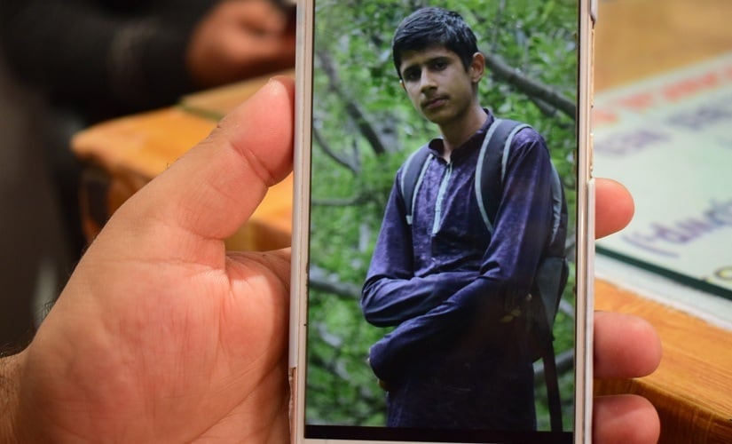 An image of Sajad Ahmad Sheikh, who was picked up by forces in a midnight raid, displayed on a relative's mobile phone. Firstpost/Qisar Mir