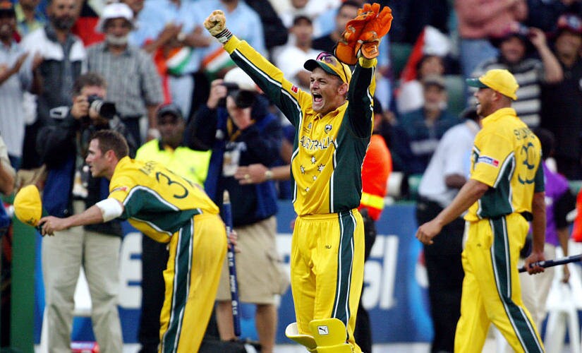 Australian wicketkeeper Adam Gilchrist (C) celebrates as Damien Martyn (L) bows to the crowd and Andrew Symonds (R) looks on after Australia won the final of the ICC Cricket World Cup played at the Wanderers Stadium in Johannesburg 23 March 2003. Batting first, Australia scored 359-2 from their 50 overs, their highest ever one-day total and then dismissed India for 234 to win by 125 runs. AFP PHOTO/William WEST (Photo by WILLIAM WEST / AFP)