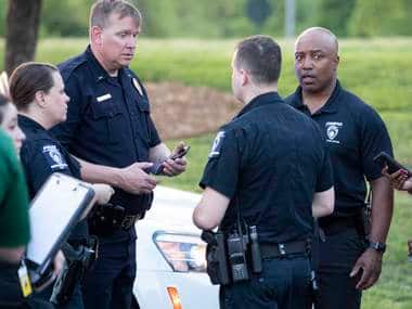 People gather across from the campus of UNC Charlotte after a shooting at the school AP