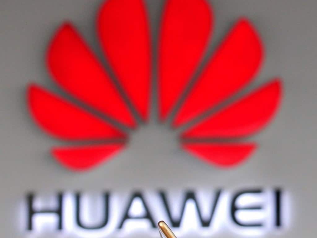 A man holding his phone walks past a Huawei shop in Beijing, China December 12, 2018. REUTERS/Jason Lee - RC14F65F1E70
