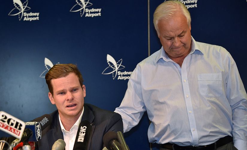 Cricketer Steve Smith (L) is comforted by his father Peter as he reacts at a press conference at the airport in Sydney on March 29, 2018, after returning from South Africa. - Distraught Australian cricketer Steve Smith on March 29 accepted full responsibility for a ball-tampering scandal that has shaken the sport, saying he was devastated by his "big mistake". (Photo by PETER PARKS / AFP) / -- IMAGE RESTRICTED TO EDITORIAL USE - STRICTLY NO COMMERCIAL USE --