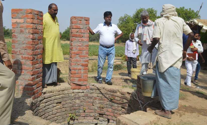 Heera Lal inspecting well with villagers in Banda. Manoj Kumar/101Reporters