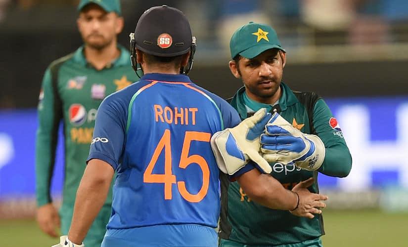Pakistan’s captain Sarfraz Ahmed (R) and Indian team captain Rohit Sharma (L) leave the field after India won by 9 wickets during the one day international (ODI) Asia Cup cricket match between Pakistan and India at the Dubai International Cricket Stadium in Dubai on September 23, 2018. (Photo by ISHARA S. KODIKARA / AFP)