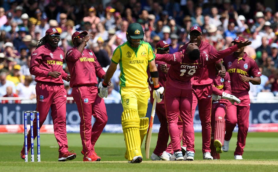 West Indies' Sheldon Cottrell (CR) celebrates with teammates as Australia's Usman Khawaja (CL) walks off after losing his wicket for 13 during the 2019 Cricket World Cup group stage match between Australia and West Indies at Trent Bridge in Nottingham, central England, on June 6, 2019. (Photo by Paul ELLIS / AFP) / RESTRICTED TO EDITORIAL USE