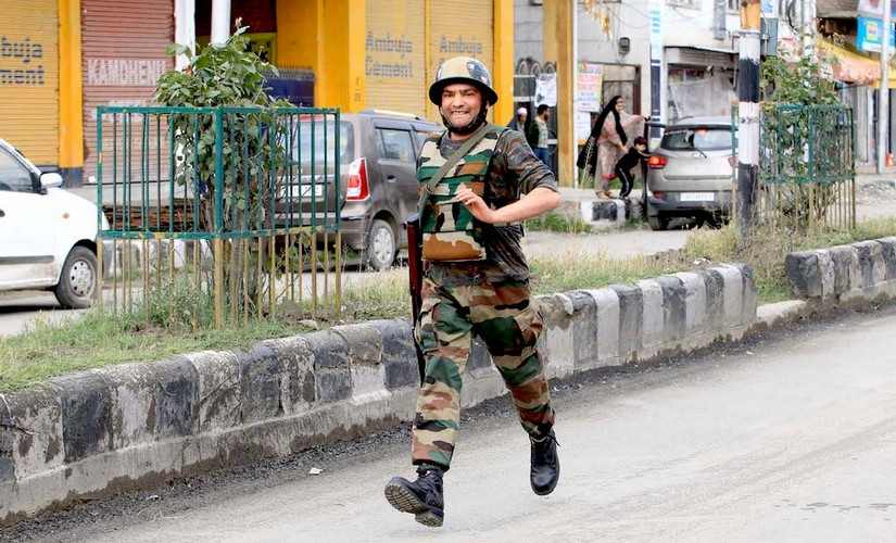 An army personnel runs towards an encounter site in Kashmir. Hilal Shah