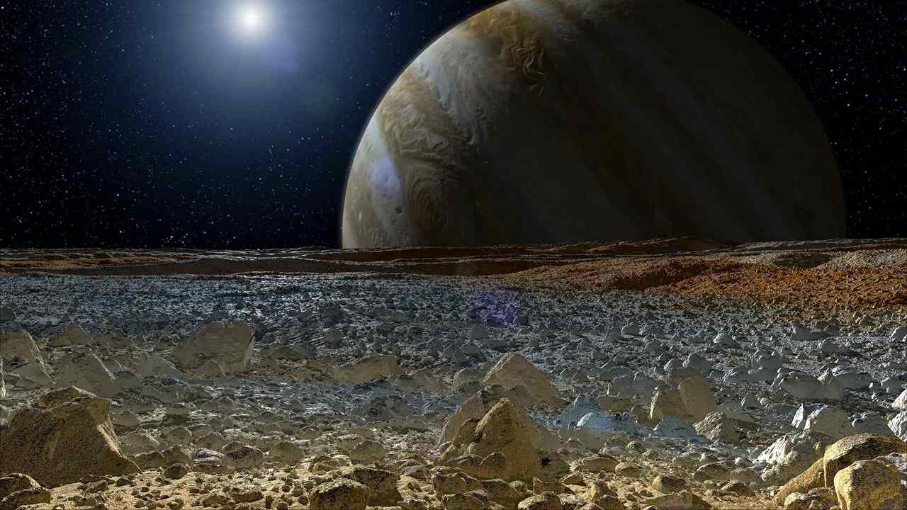 This artist's concept shows a simulated view from the surface of Jupiter's moon Europa. Europa's potentially rough, icy surface, tinged with reddish areas that scientists hope to learn more about. Image courtesy: NASA/JPL