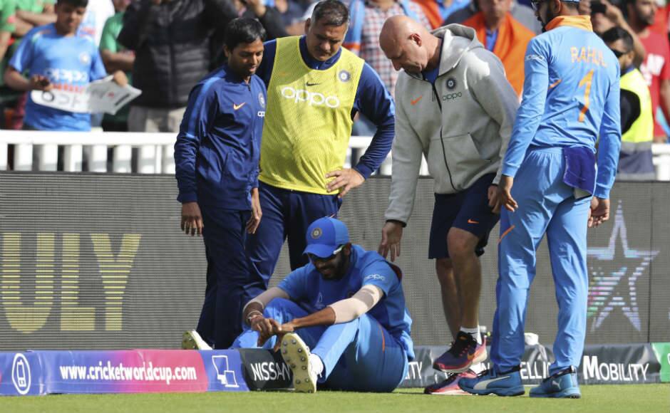 Jasprit Bumrah is attended to by the Indian physio Patrick Farhart after hurting his shoulder while putting in a slide near the boundary. AP