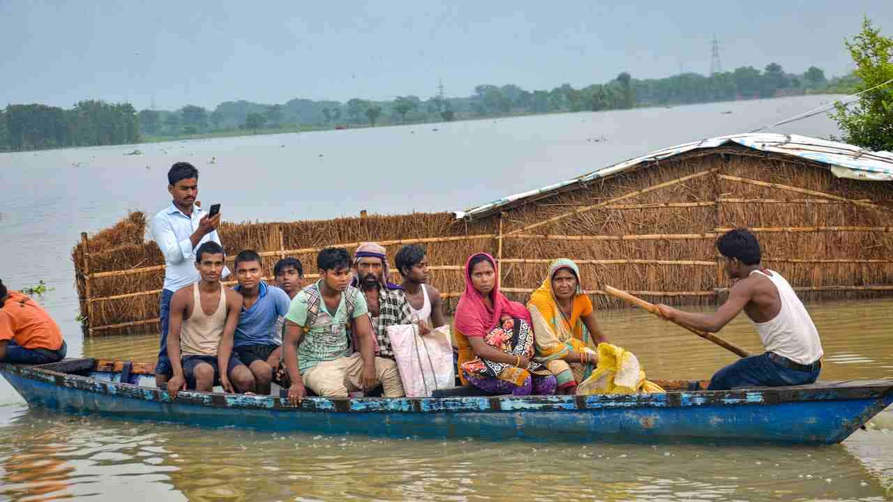 Flood-affected villagers use a boat to take a patient to hospital in Muzaffarpur. PTI
