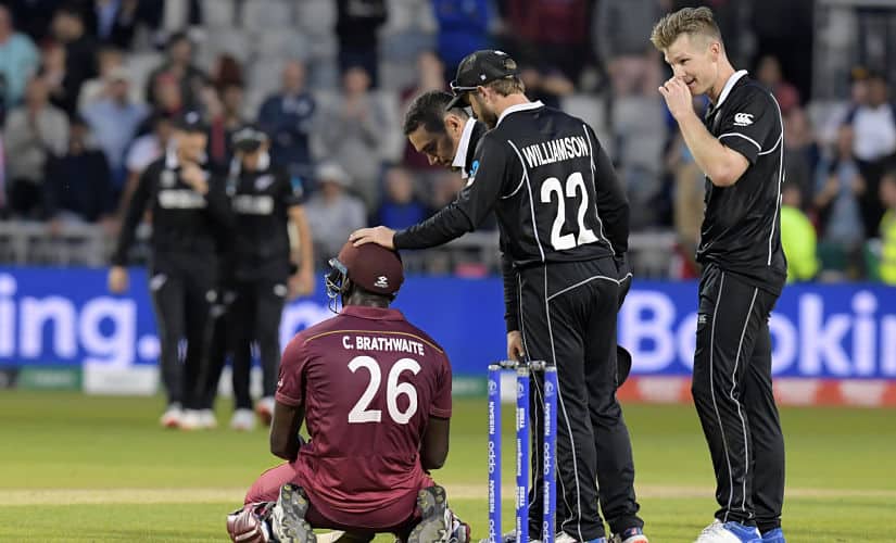 West Indies’ Carlos Brathwaite (C) is consoled by New Zealand players having fallen short in the run-chase during the 2019 Cricket World Cup group stage match between West Indies and New Zealand at Old Trafford in Manchester, northwest England, on June 22, 2019. (Photo by Dibyangshu Sarkar / AFP) / RESTRICTED TO EDITORIAL USE