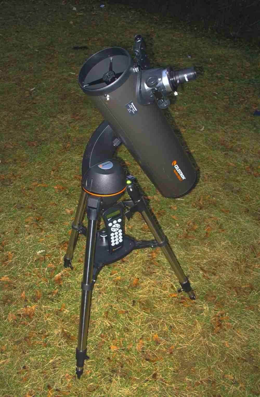 A telescope mounted on an alt-azimuth GoTo. Note the keypad, resting on the platform between the tripod's legs, which is the telescope's hand control. Batteries are stored in the circular compartment just above the tripod. In this picture, the compartment is just above the hand control. Image: Wikimedia Commons