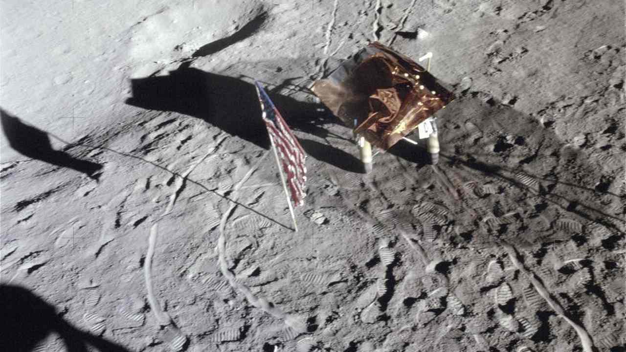Footprints, wheel tracks and the Rickshaw–type portable workbench on the Moon, with the US flag in 1971. Credit: NASA