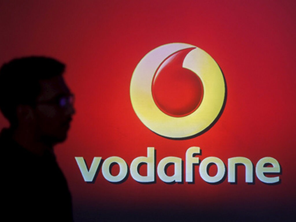 A man casts a silhouette onto an electronic screen displaying a Vodafone logo, in Mumbai, India, in this file photograph dated November 10, 2015. Mobile phone company Vodafone met expectations announcing on February 4, 2016 a 1.4 percent rise in revenue in its third quarter, its sixth consecutive quarter of growth, as recovery in Europe gained pace. REUTERS/Shailesh Andrade/files - RTX25DI6