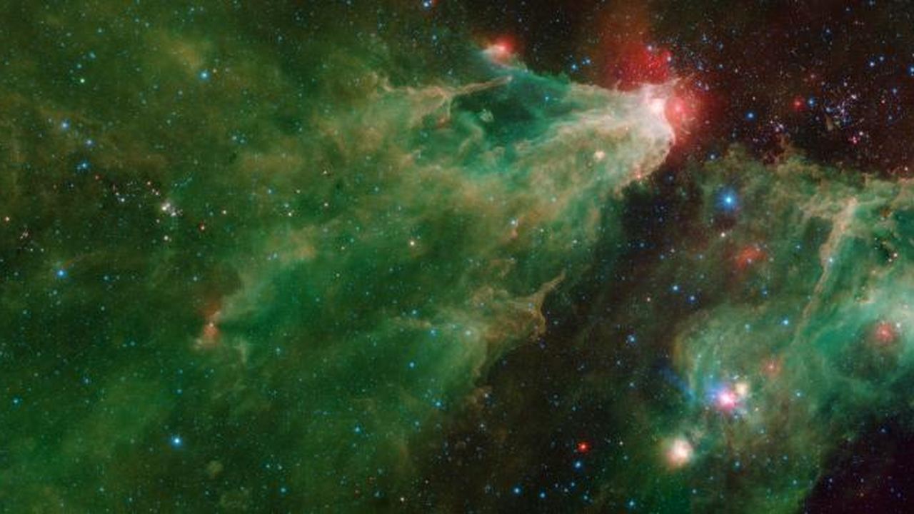 This image is a mosaic of generational stars that has been taken by the Spitzer telescope. One can see multiple star clusters that have formed at different time periods but born from the same clumps of cloud and gas. The green and orange light is a faraway nebula. Image credit: NASA/JPL This image is a mosaic of generational stars that has been taken by the Spitzer telescope. One can see multiple star clusters that have formed at different time periods but born from the same clumps of cloud and gas. The green and orange light is a faraway nebula. Image credit: NASA/JPL