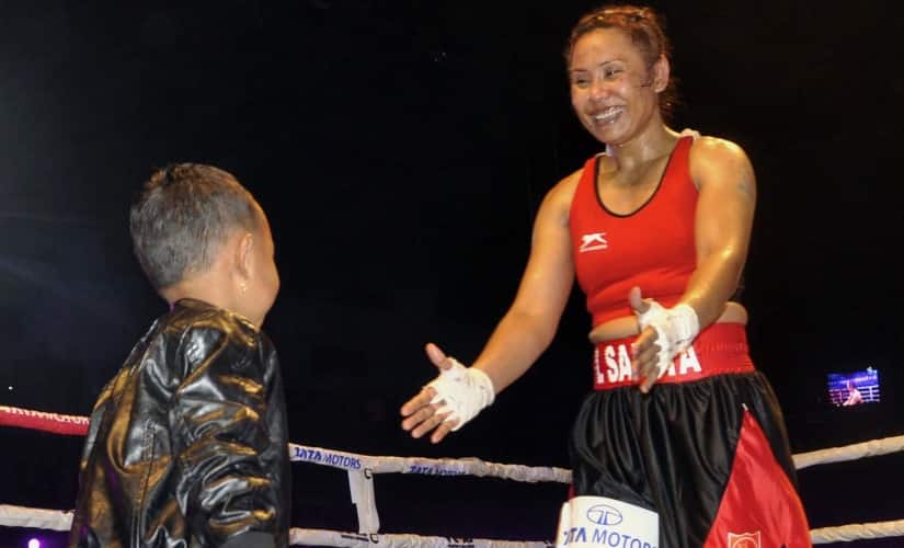 Boxer Sarita Devi (L) shares a moment with her son after winning her bout