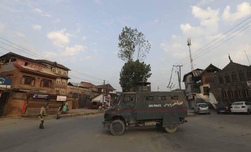 An armored vehicle is parked in the middle of a deserted street during curfew in central Srinagar. AP