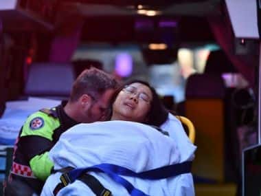 A woman is taken by ambulance, as police officers investigate a scene following reports of aa stabbing in Sydney, Australia, August 13, 2019. Dean Lewis/AAP/via REUTERS 