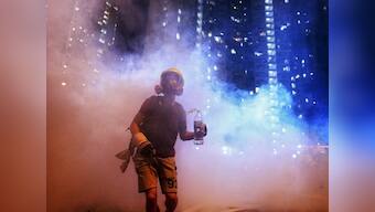 Hong Kong riot police fires tear gas rounds at protestors in tourist district; rioters break glasses of police cars, cover walls with graffiti