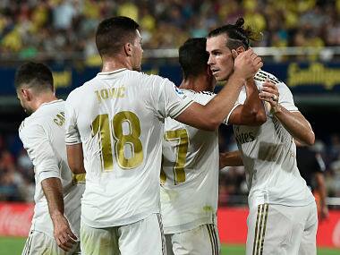 Real Madrid’s Welsh forward Gareth Bale (R) celebrates with teammates after scoring during the Spanish league football match Villarreal CF against Real Madrid CF at La Ceramica stadium in Vila-real on September 1, 2019. (Photo by Josep LAGO / AFP)