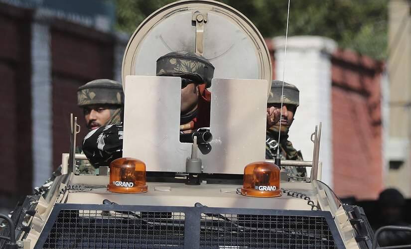 Indian paramilitary soldiers move in armored vehicles near the residence of NC president Farooq Abdullah in Srinagar. AP